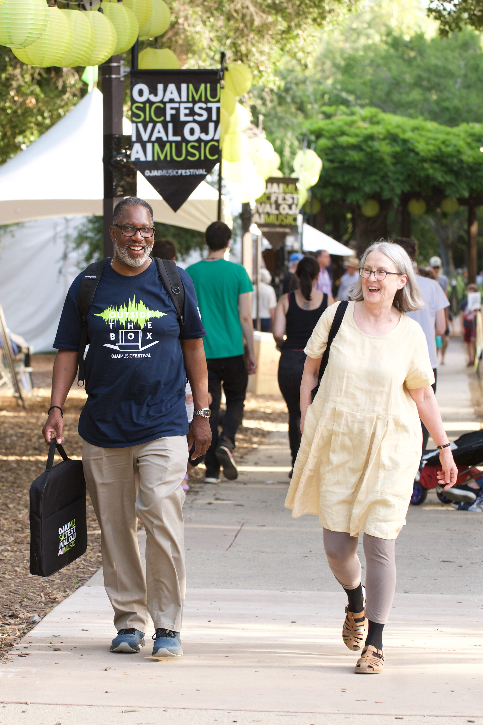 Concert-goers happily walking through Libbey Park