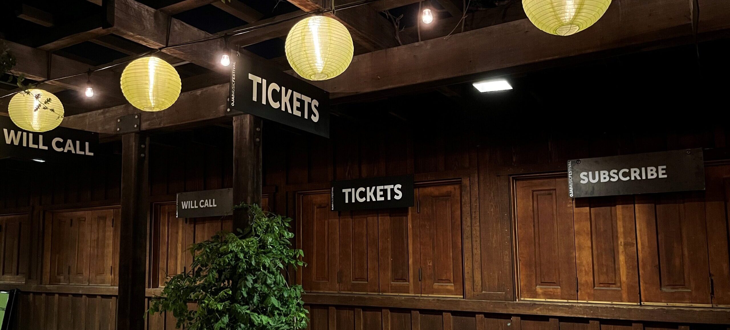 Libbey Park Box Office at night, illuminated by green lanterns